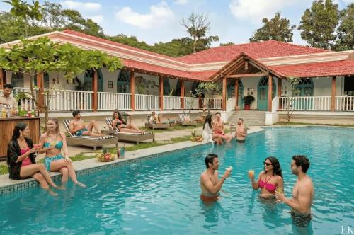 a group of people sitting in a swimming pool at EKOSTAY - Blue Tiffany Villa in Nerul