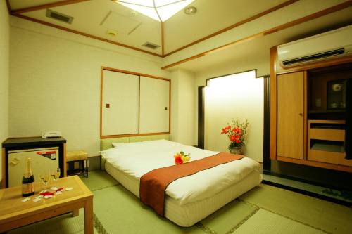 a bedroom with a large bed and a table at ホテル グリーンヒルAdult only in Tokyo