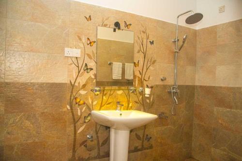 a bathroom with a sink and a shower with a mirror at Orange Jesmine Unawatuna in Unawatuna
