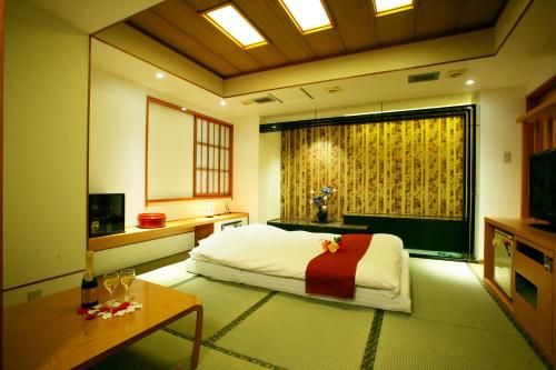 a bedroom with a bed and a table and a window at ホテル グリーンヒルAdult only in Tokyo