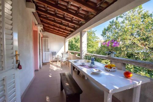 een balkon met een tafel en een bank op een huis bij Apartments Breza in Razvala