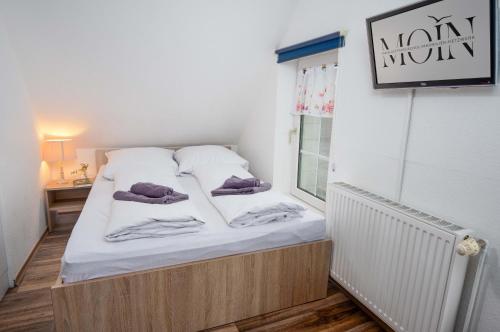 a small bedroom with a bed with towels on it at Ferienwohnung Krabbe in Manslagt