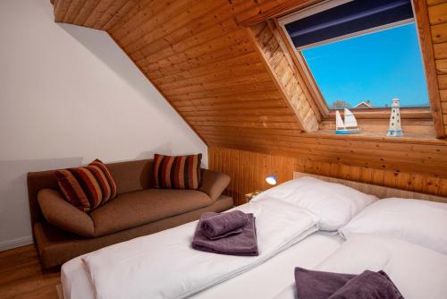 a bedroom with a bed and a couch and a window at Ferienwohnung Hummer in Manslagt