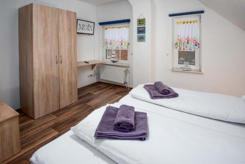 two beds in a room with purple towels on them at Ferienwohnung Auster in Manslagt