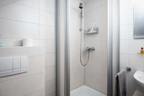 a white bathroom with a shower and a sink at Ferienwohnung Auster in Manslagt