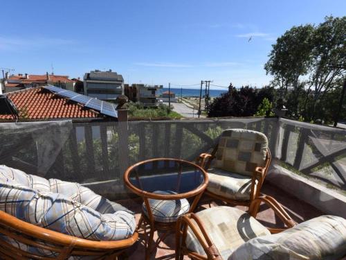 um pátio com duas cadeiras e duas cadeiras em uma varanda em Casa Plagia by RentalsPro - Nea Plagia Halkidiki em Nea Plagia