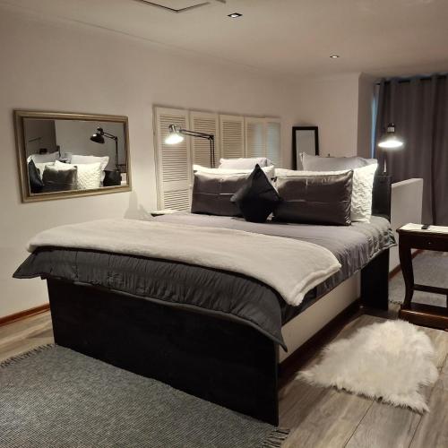 a bedroom with a large bed with pillows and a mirror at Mpushini Falls Resort in Eshowe