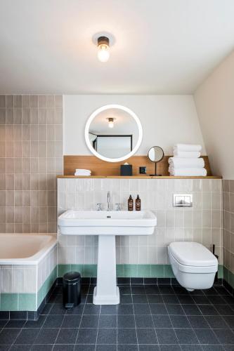 a bathroom with a sink and a tub and a toilet at Le Grand Quartier in Paris