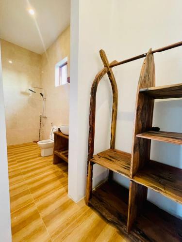 a bathroom with a wooden shelf in a room at Leo Home in Nungwi