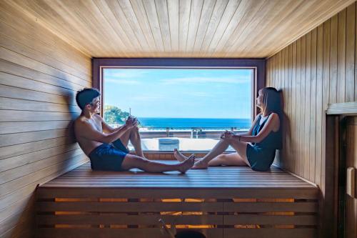 a man and a woman sitting in a sauna at akesuke in Minamiawaji