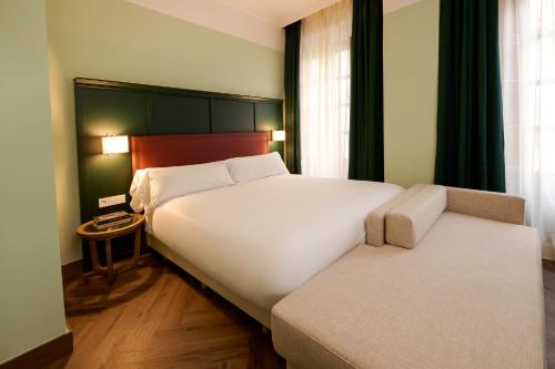 Un dormitorio con una cama blanca grande y una ventana en Honest Granada Hotel, en Granada