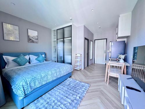 a bedroom with a blue bed and a desk at Title Legendary 7 floor Mountain View in Bang Tao Beach