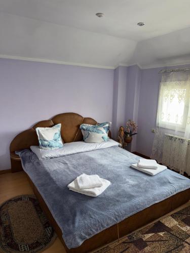 a bedroom with a bed with two towels on it at ЯВіС in Mamaivci Village