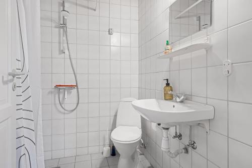 a white bathroom with a toilet and a sink at Naturskønt nær Ribe Vikingecenter, se og oplev den gamle by Ribe in Ribe