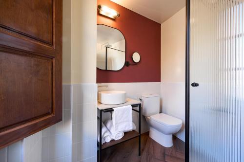 un baño con inodoro y espejo en Honest Granada Hotel, en Granada