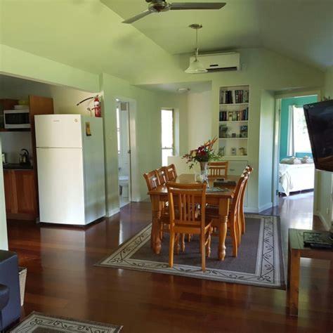 a kitchen with a table and chairs and a refrigerator at Bellingen Riverside Cottages in Bellingen