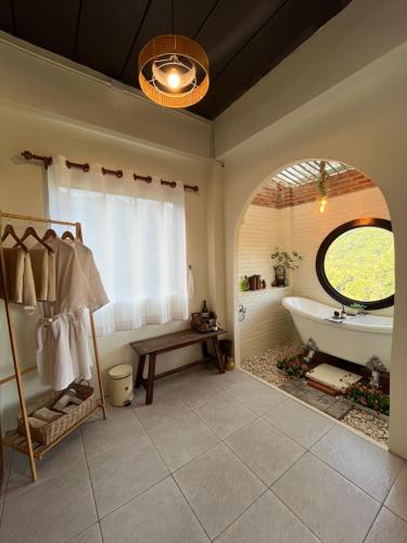 a large bathroom with a tub and a window at หมี่ก่าโฮมสเตย์ in Ban Pha Mi
