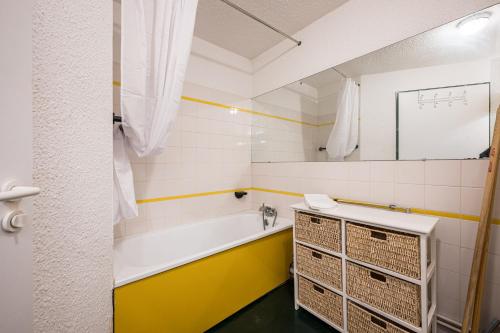 une salle de bains avec baignoire et lavabo dans l'établissement Appartement Necou 105, aux Menuires