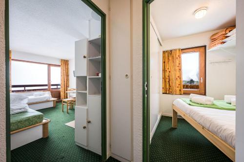 une chambre avec un lit superposé et un miroir dans l'établissement Appartement Necou 105, aux Menuires