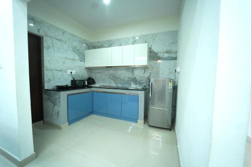 a kitchen with blue cabinets and a stainless steel refrigerator at Nandan Elite 3bhk in Mysore