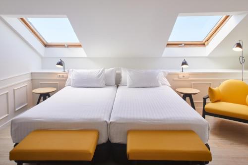 a bedroom with a large bed and two chairs at Dorma Sardinero in Santander