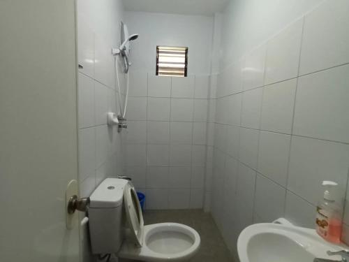 ein weißes Badezimmer mit Toilette und Waschbecken in der Unterkunft Grae’s Apartelle in Moalboal