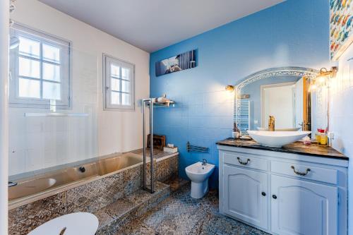a bathroom with a sink and a tub and a toilet at Chambre D'hote Chez Amaya in Gujan-Mestras