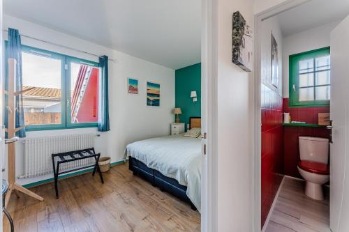 a bedroom with a bed and a toilet and a window at Chambre D'hote Chez Amaya in Gujan-Mestras