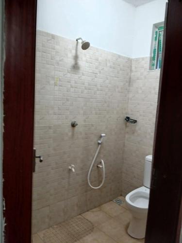 a bathroom with a shower with a toilet at Mash Studio Apartment in Bamburi in Mombasa