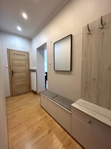 a living room with a bench and a mirror at Apartament Centrum 3 pokojowy z widokiem na morze in Sarbinowo