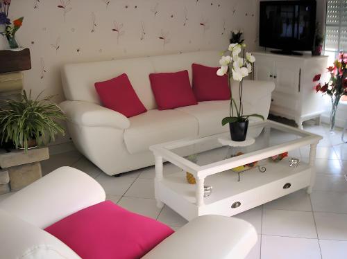 a living room with a white couch and red pillows at Chambre d'hote Reine in Cancale
