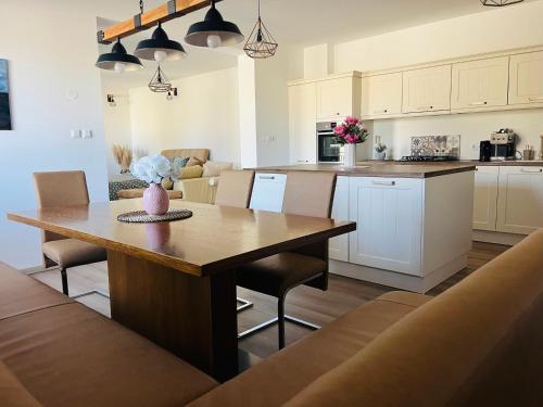 Apartment Country House Zaton في Tišina: مطبخ وغرفة معيشة مع طاولة وكراسي خشبية