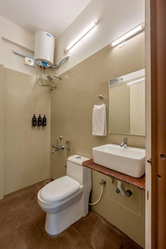 a bathroom with a white toilet and a sink at Wandr Hotel- HSR Layout, Sector 7 in Bangalore
