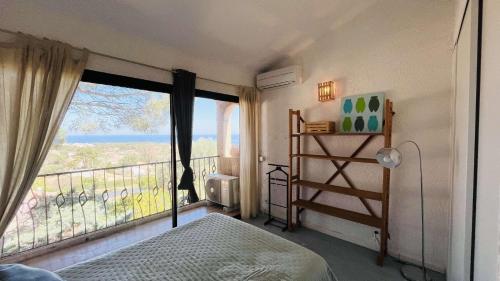 a bedroom with a balcony with a bed and a window at Appartement Cocody 215 LUMIO in Lumio