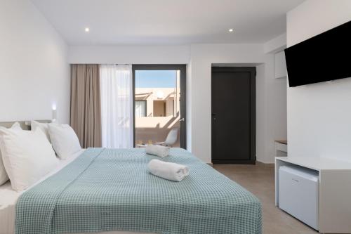 ein Hotelzimmer mit einem Bett mit einer grünen Decke in der Unterkunft Golden Bee Lifestyle in Stalida