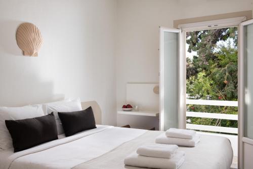 ein Schlafzimmer mit einem weißen Bett, auf dem Handtücher liegen in der Unterkunft Terra Maria Hotel in Mykonos Stadt