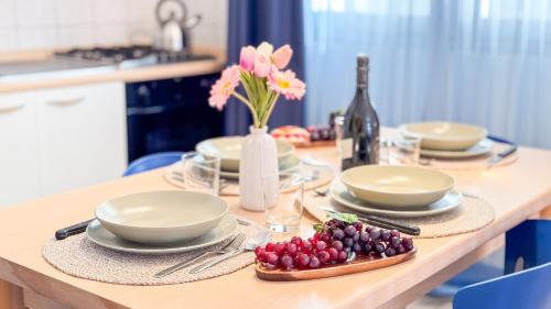a table with plates and bowls of grapes and a bottle of wine at Liam Leo Suite by Ca-Sa Check in Chioggia