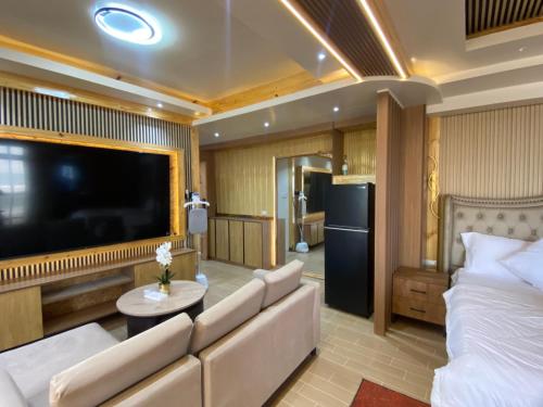 a living room with a couch and a large flat screen tv at The Baywalk Sunset Resort in Agoo