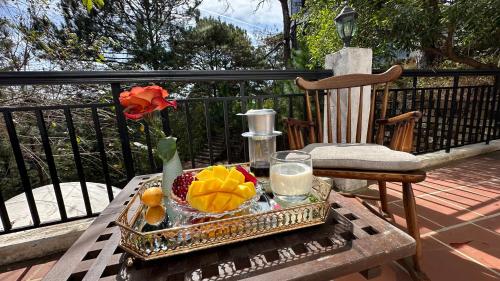 a table with a tray of fruit on a balcony at Hotel Des Pins Dalat in Xuan An