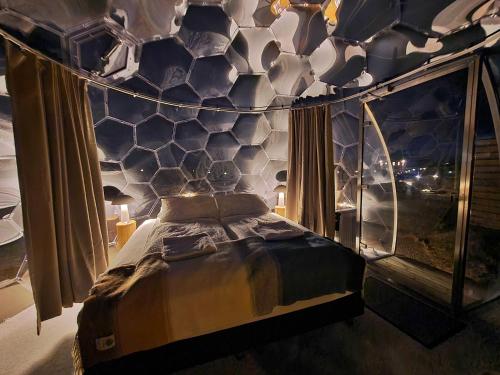 a bedroom with a bed with a hexagonal wall at Aurora Igloo North in Hvammstangi