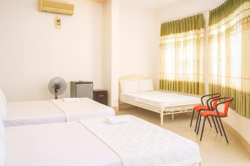 a room with two beds and two chairs at Nam Dương 3 Hotel in Phan Rang