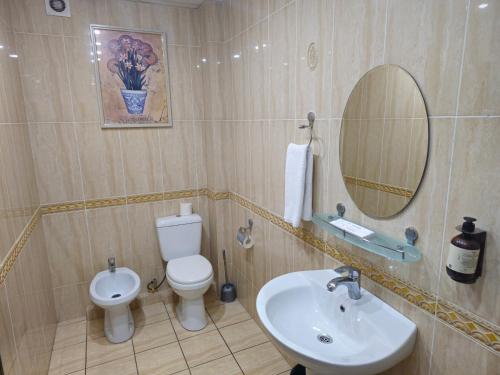 een badkamer met een toilet, een wastafel en een spiegel bij Arien Plaza in Muruntau