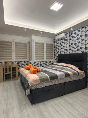 een slaapkamer met een groot bed en een tafel bij Central Square Apartment in Skopje