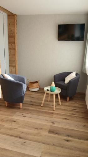 L'Amandier في Saint-Martin-sur-le-Chambre: غرفة معيشة مع كرسيين وطاولة قهوة