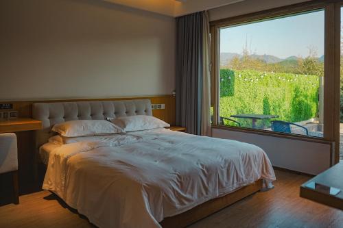 Una cama o camas en una habitación de Qiyun·Anji Chashan Yelu Hot Spring Homestay