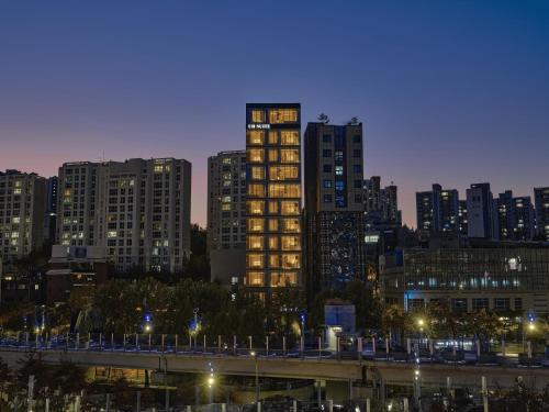 a city skyline with tall buildings at night at UH Suite The Seoul in Seoul