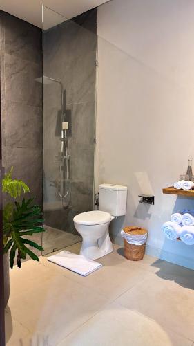 a bathroom with a shower and a toilet in a room at 3BR Tala Villa Ubud in Ubud