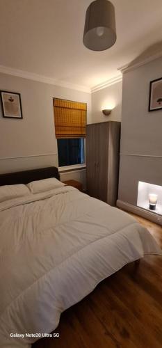 a bedroom with a large bed and a window at Dartford Haven in Dartford