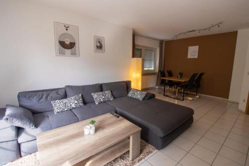 een woonkamer met een blauwe bank en een tafel bij Ferienwohnung Josi in Ebermannstadt