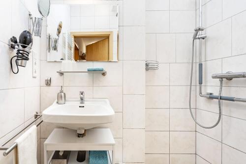 Ferienwohnung Am Kirchplatz في باد وونينبرج: حمام أبيض مع حوض ودش